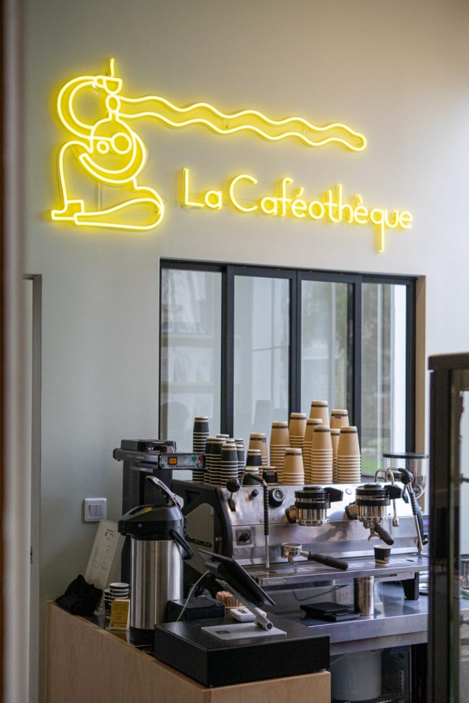 Enseigne néon jaune La Caféothèque au-dessus du comptoir et de la machine à espresso, à Reid Hall