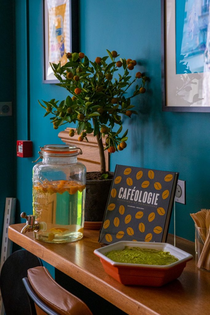 Comptoir de La Caféothèque Reid Hall : fontaine d’eau, petit agrume et le livre « Caféologie »